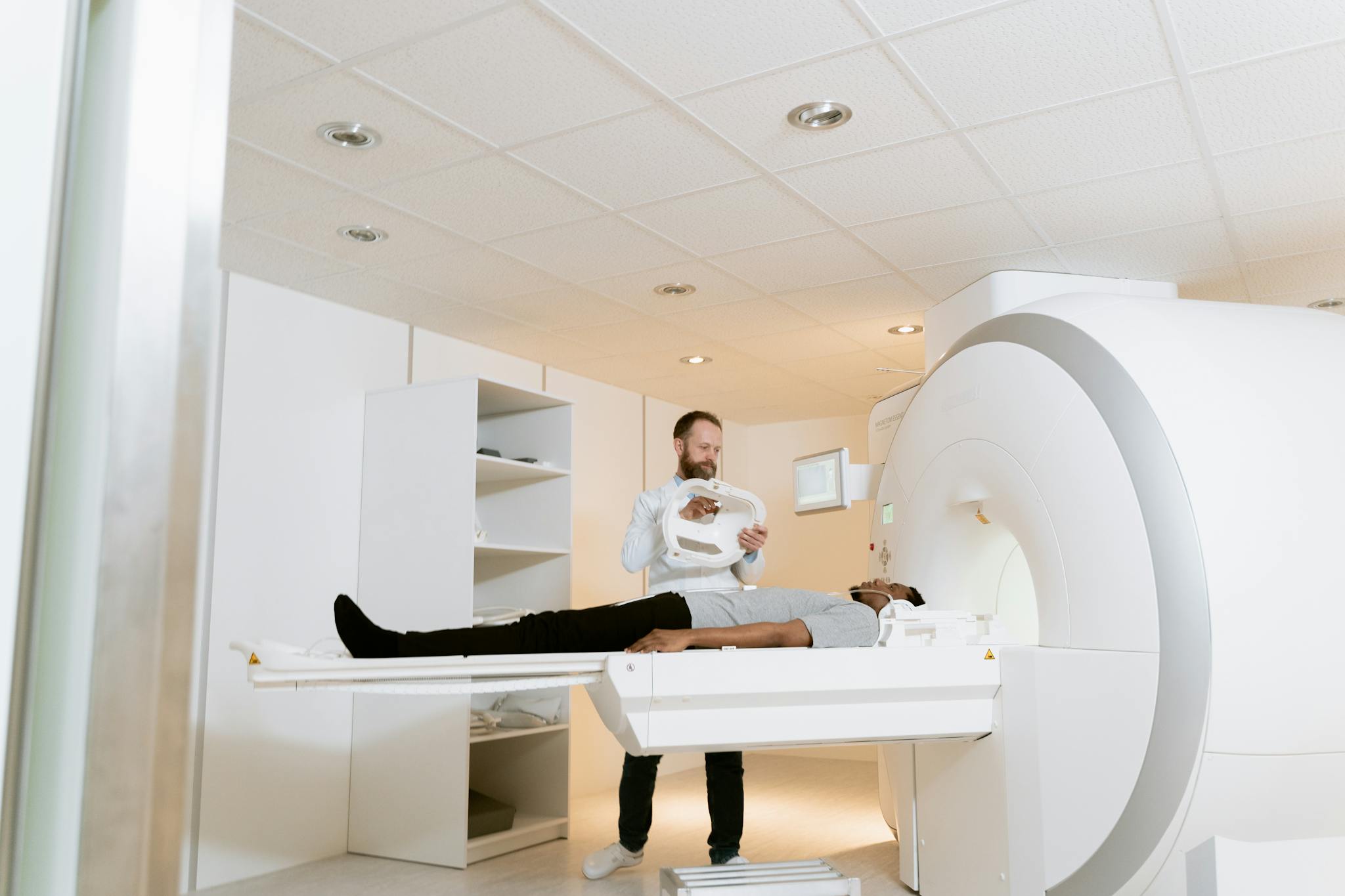 A doctor assists a patient during an MRI scan in a modern medical clinic.