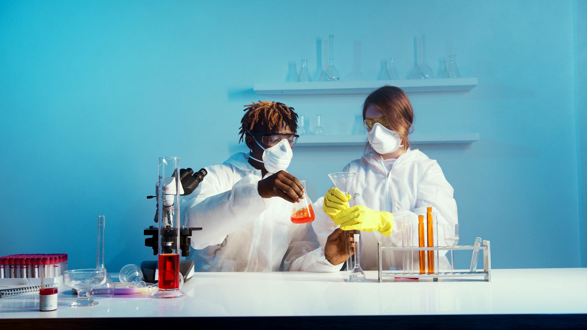 Two scientists in lab coats conducting chemical experiments in a laboratory.