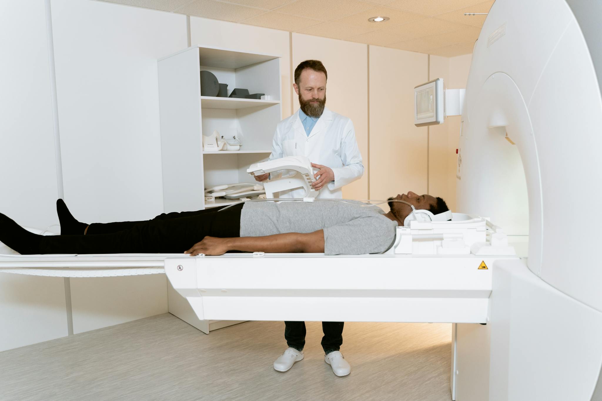 A healthcare professional prepares a patient for an MRI scan in a modern clinic.