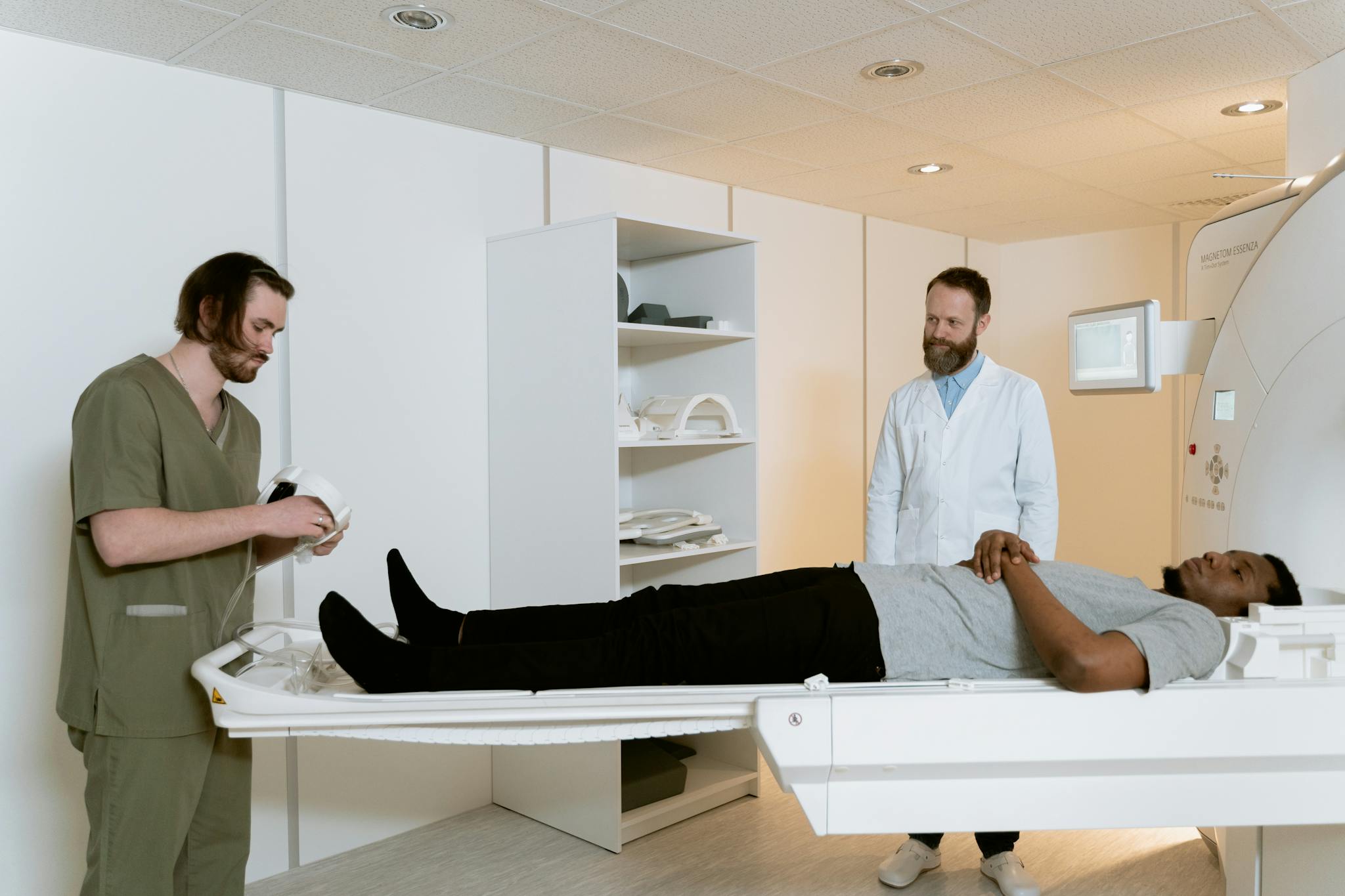 Doctors and patient during MRI scan in medical facility.